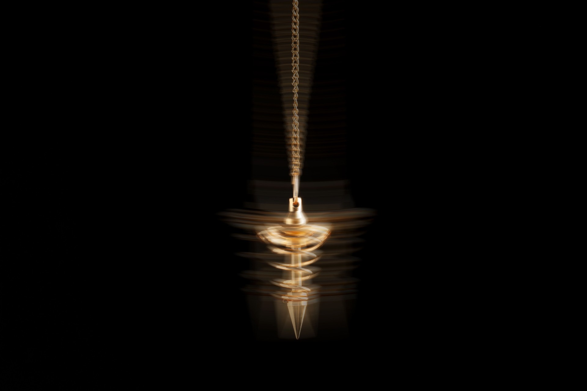 Hypnosis session. Golden pendulum swinging on black background, motion blur effect